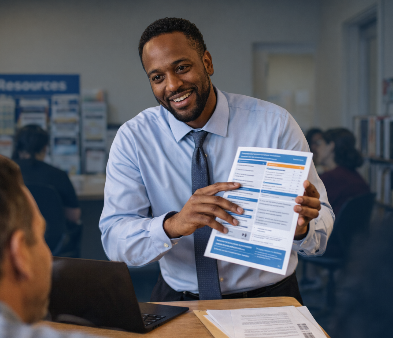 Business owner presenting information to clients in a support services office with resource shelves